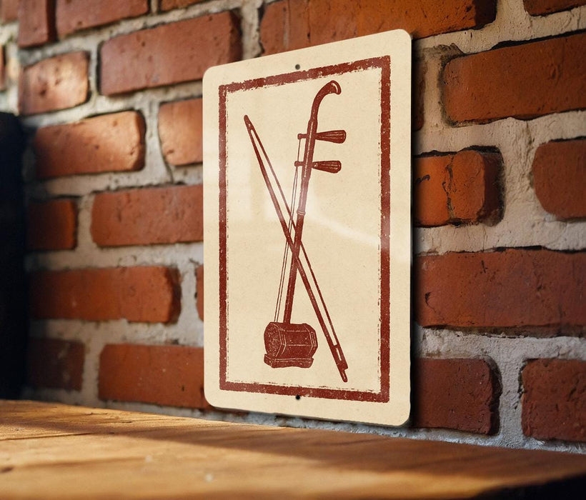 a sign with a red and white design, depicting a musical instrument, such as a violin or cello, against a brick wall background.