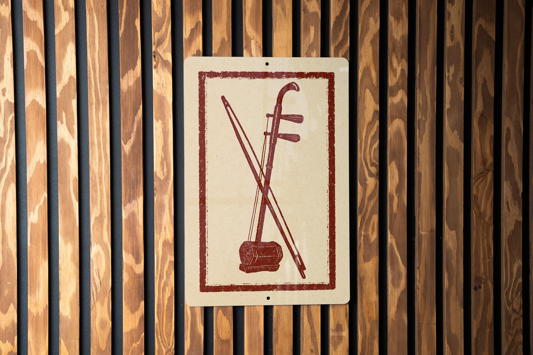 a sign with a red and white design, depicting a musical instrument, such as a violin or cello, against a wooden background.
