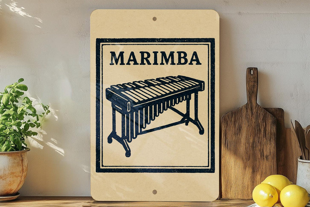 a wooden sign with a black and white illustration of a musical instrument, specifically a marimba, and the word "MARIMBA" written on it. The sign is placed on a wooden surface, with a potted plant to the left and a cutting board to the right. There are also some lemons visible in the image.