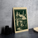 A metal sign with a green and white illustration of a house, featuring a chimney and trees, is displayed on a gray countertop.