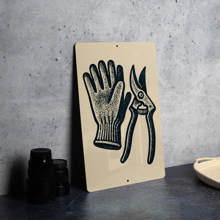 a sign with a hand and a pair of scissors, placed on a countertop next to some black camera lenses.