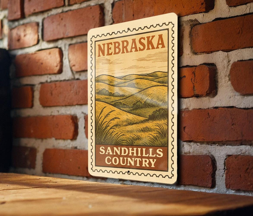 A metal sign with the text "NEBRASKA SANDHILLS COUNTRY" is displayed on a brick wall.