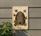 a beehive on a wall, with four bees surrounding it.