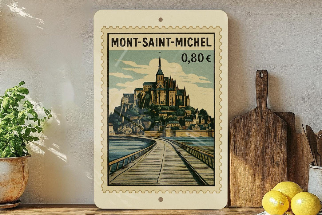 A vintage-style postage stamp depicting the Mont-Saint-Michel castle in France, with a wooden board and a potted plant in the foreground.