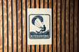A sign for kitesurfing is displayed on a wooden wall.