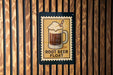 A sign with a picture of a root beer float on it, mounted on a wooden wall.