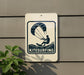 A sign indicating kitesurfing is mounted on a wall, with a plant visible to the left.