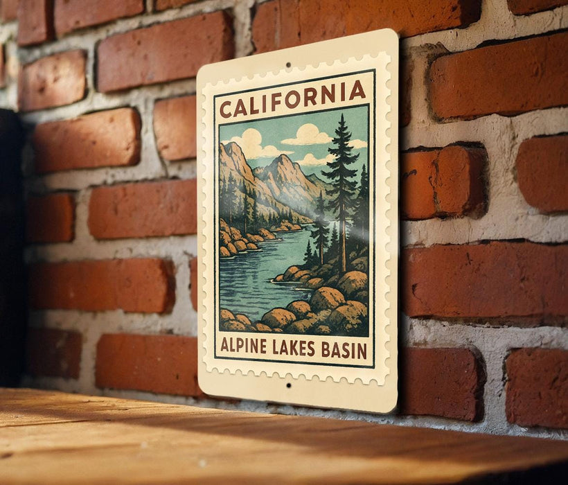 A vintage-style metal sign with a scenic illustration of a mountain landscape and a river, mounted on a brick wall.