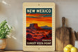 A vintage-style poster of the Sunset Vista Point in New Mexico, featuring a desert landscape with mountains in the background and a warm sunset sky.