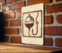A sign with a fishing symbol is mounted on a brick wall.