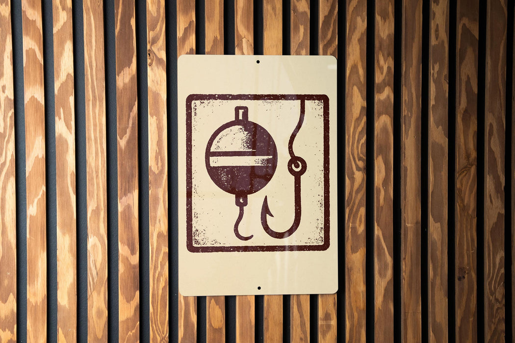 a sign with a fishing symbol, such as a bobber or a fishing line, mounted on a wooden wall.
