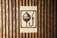 a sign with a fishing symbol, such as a bobber or a fishing line, mounted on a wooden wall.