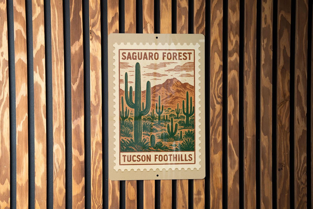 A wooden wall with a framed poster of a desert landscape featuring cacti and mountains.