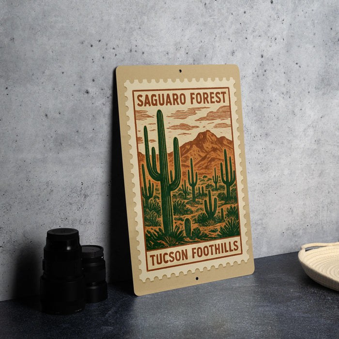 A metal sign with a desert landscape and mountains, featuring a cactus illustration, is displayed on a table.