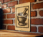 a wooden table with a sign featuring a bowl and a mortar and pestle on it, mounted on a brick wall.