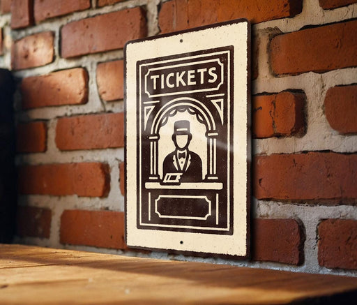 A sign with the word "TICKETS" on it is displayed on a brick wall.