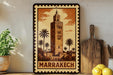 A framed illustration of the Marrakech Tower, a famous landmark in Morocco, is displayed on a shelf next to a wooden cutting board and some potted plants.