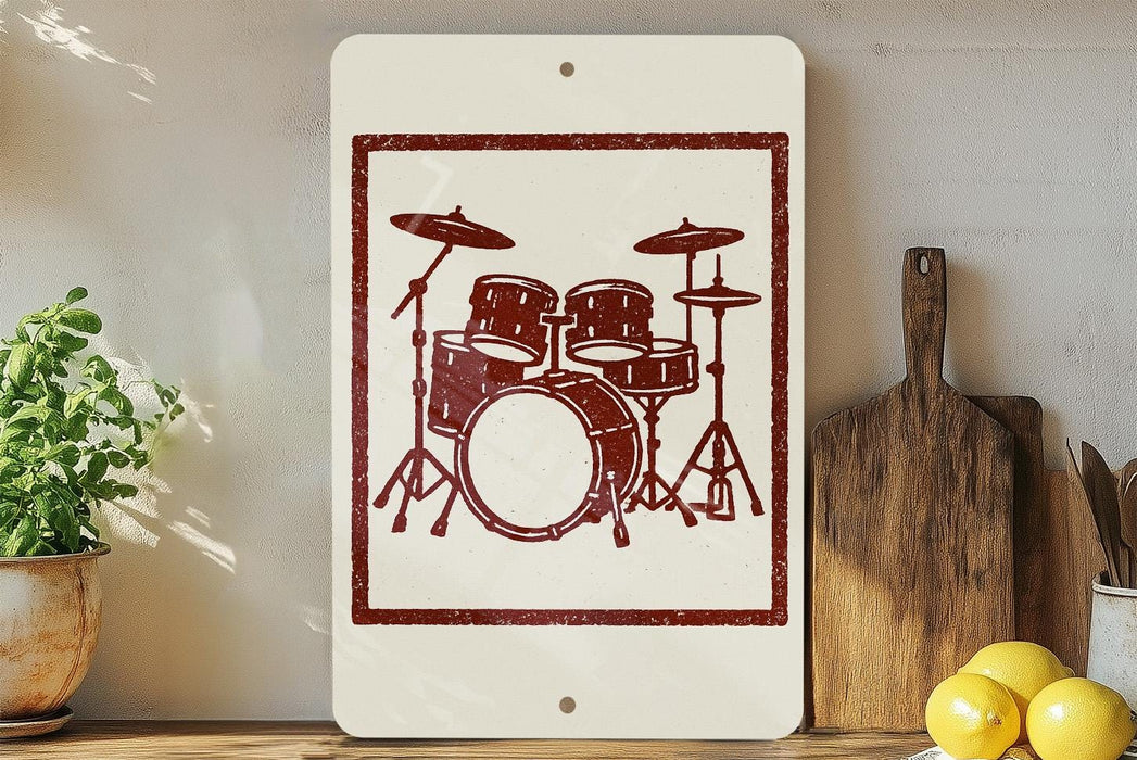 a white sign with a red drum set design on it, placed on a wooden surface next to a wooden cutting board and some lemons.