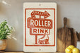 a sign for a roller rink, with a roller rink sign and a wooden cutting board with a lemon on it.