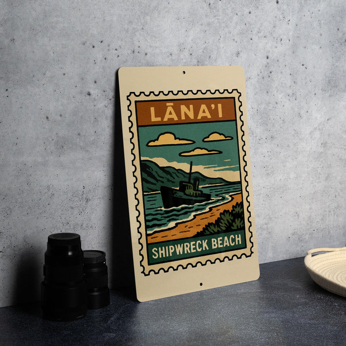 A vintage-style metal sign with a shipwreck beach illustration, featuring a ship and a beach scene, is displayed on a gray wall.