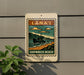 A sign for "Lana'i Shipwreck Beach" is displayed on a wall, featuring a vintage-style illustration of a shipwreck on a beach.