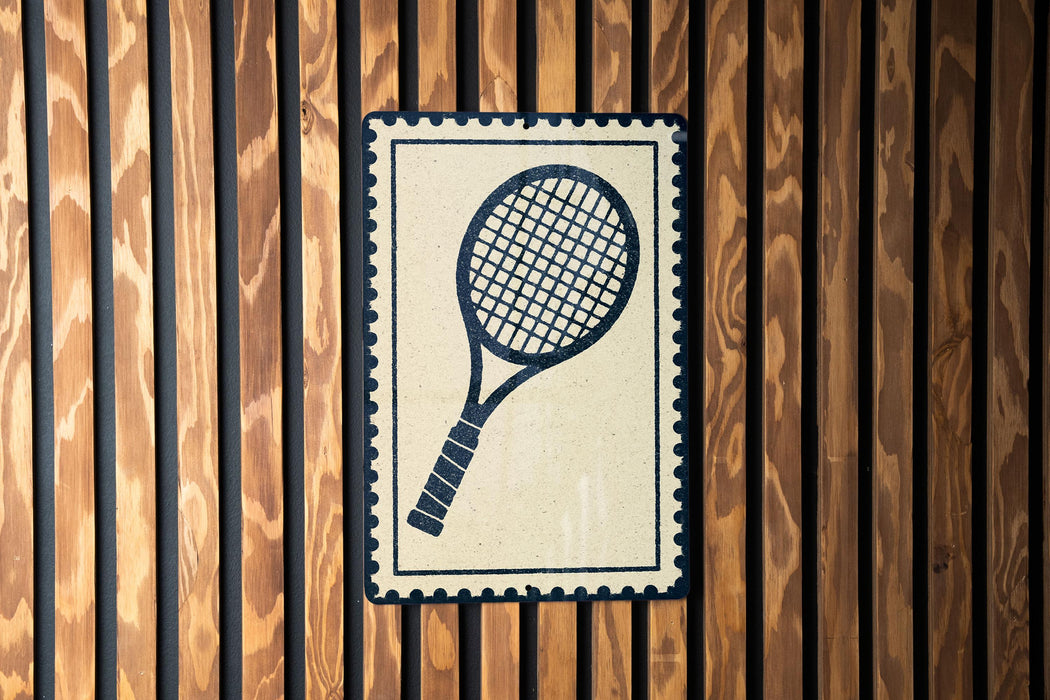 A tennis racket is displayed on a wooden wall, with a decorative border around it.
