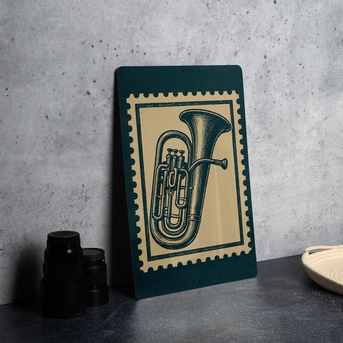 a green and beige framed poster of a tuba, placed on a table next to some black camera lenses.