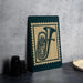 a green and beige framed poster of a tuba, placed on a table next to some black camera lenses.