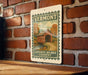 A vintage-style sign for Vermont's Covered Bridge Country is displayed on a brick wall.