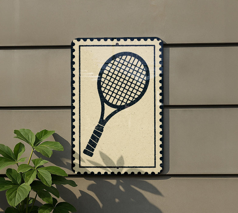 a tennis racket on a wall, with a plant to the left side.