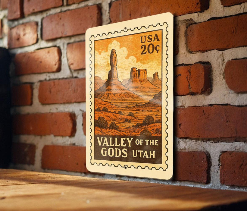 A vintage-style postage stamp depicting the Valley of the Gods in Utah, with a wooden surface in the foreground.