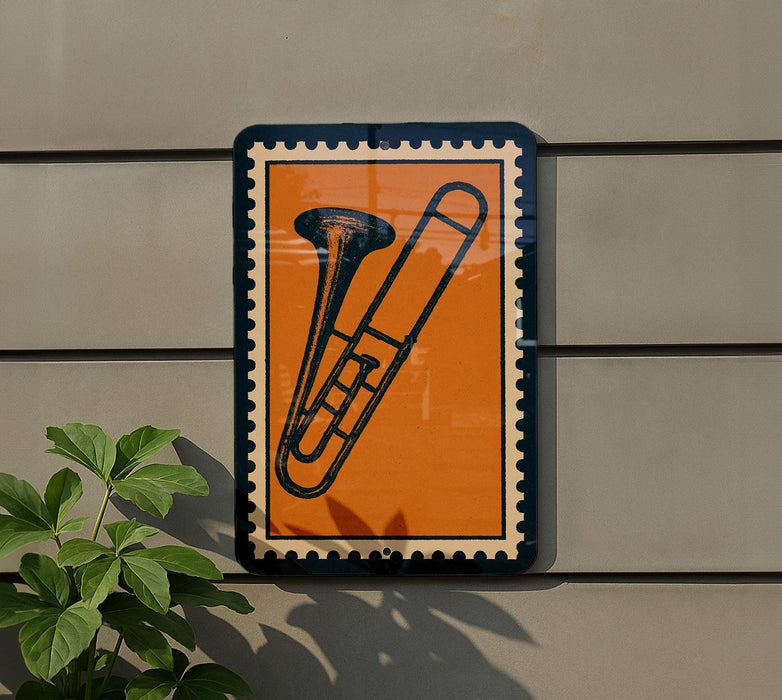 a trombone on a wall, with a plant to the left side.