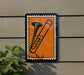 a trombone on a wall, with a plant to the left side.