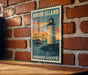 A vintage-style metal sign depicting a lighthouse and a bridge, mounted on a brick wall.