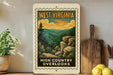 A vintage-style West Virginia postage stamp featuring a scenic mountain landscape with pine trees and rocky cliffs, displayed on a wooden shelf next to kitchen utensils and a potted plant.