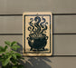 a sign with a black and white illustration of a pot with steam coming out of it, mounted on a wall.