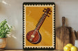 a framed illustration of a sitar, a traditional Indian stringed instrument, displayed on a shelf next to a wooden cutting board and a potted plant.