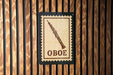 a sign with the word "OBOE" on it, which is mounted on a wooden wall.