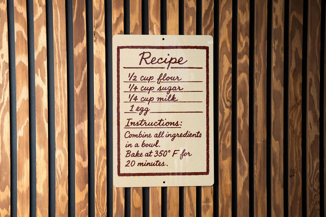a recipe sign on a wooden wall, providing instructions for combining ingredients in a bowl and baking at 350°F for 20 minutes.