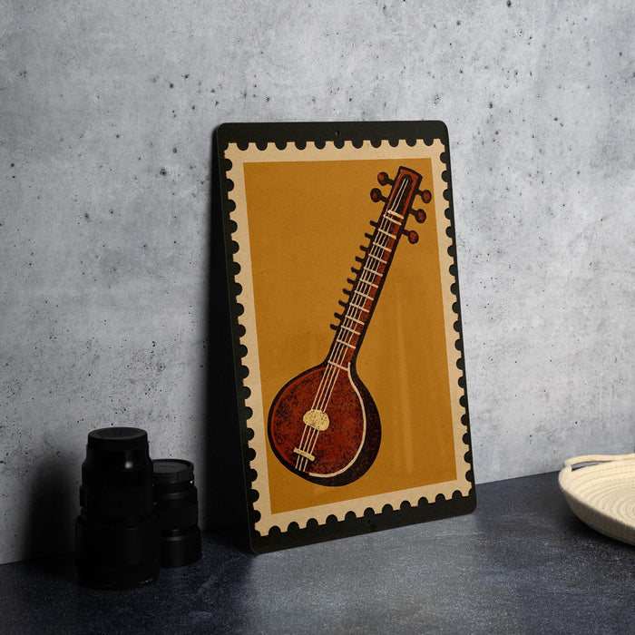 a framed illustration of a sitar, a traditional Indian stringed instrument, on a wall.
