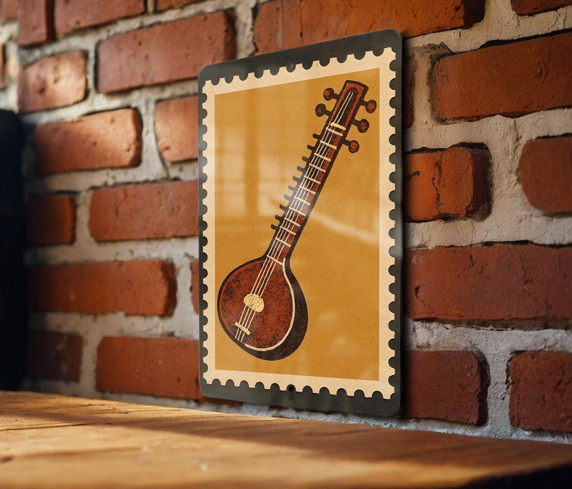 A framed image of a traditional Indian sitar, a stringed instrument, is displayed on a brick wall.