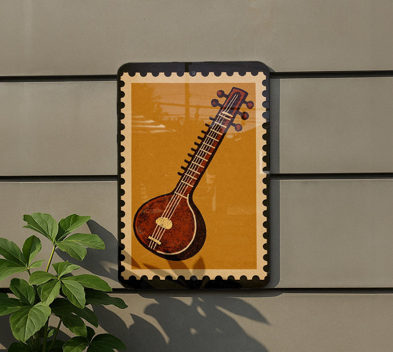 a framed illustration of a traditional Indian sitar, a stringed musical instrument, displayed on a wall.