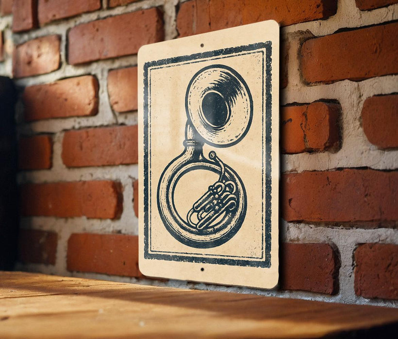 A sign featuring a black and white illustration of a brass instrument, such as a tuba or trombone, mounted on a brick wall.