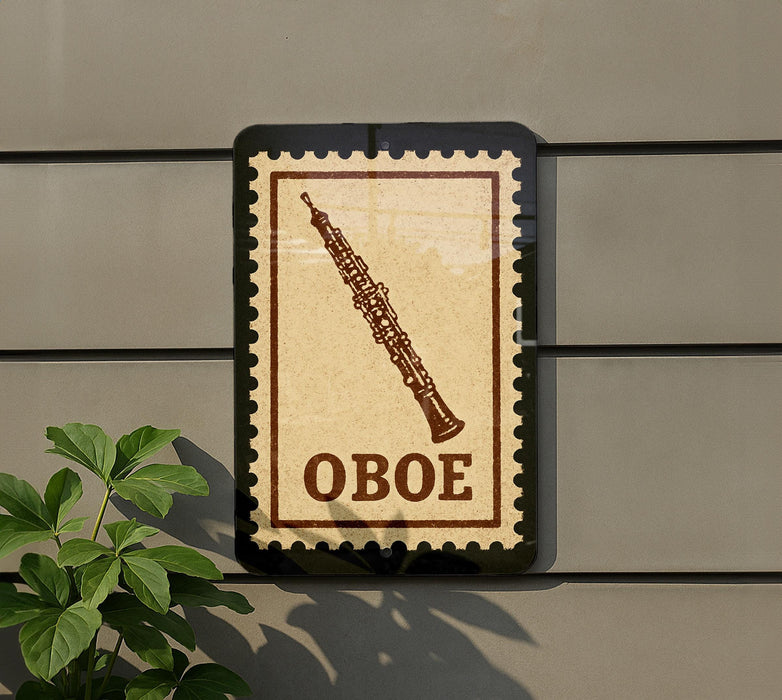 a sign with the word "OBOE" on it, mounted on a wall next to a plant.