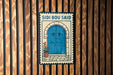 a blue door with a potted plant on the steps, and there is a sign above it that says "SIDI BOU SAID".