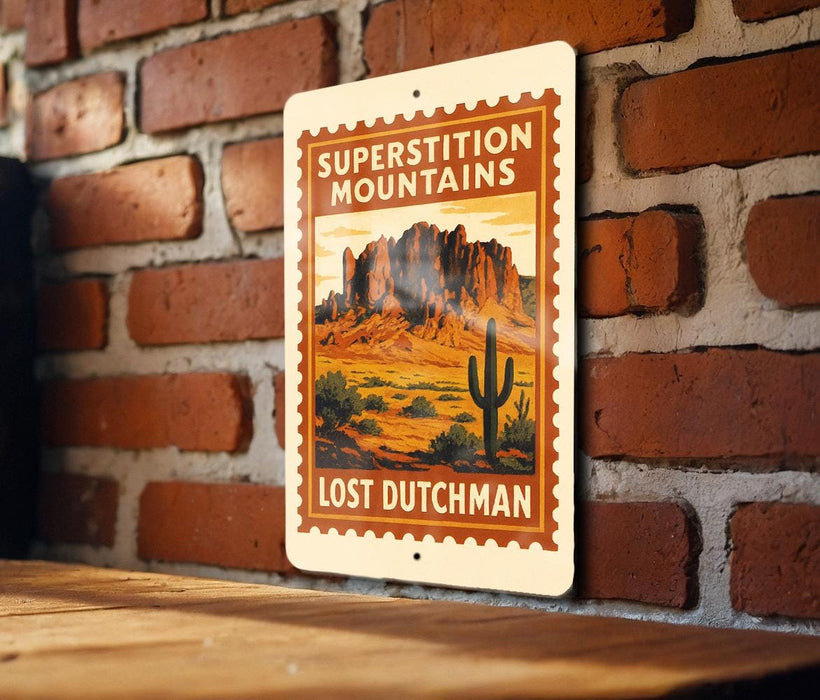 A vintage-style metal sign with a desert landscape and a cactus, mounted on a brick wall.