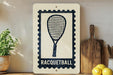 a racquetball sign on a shelf, surrounded by kitchen utensils and a potted plant.