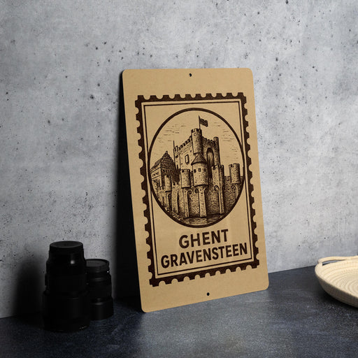 a sign with a castle illustration and the text "Ghent Gravensteen" on it, placed on a table next to some black camera lenses.