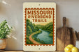 A framed poster of the Missouri River Bend Trail, featuring a scenic illustration of a winding river surrounded by lush greenery.