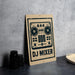 A sign for a DJ mixer is displayed on a table, with a stack of black camera lenses and a woven basket nearby.